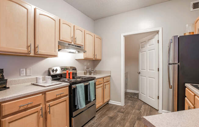 A kitchen with wooden cabinets and black appliances.