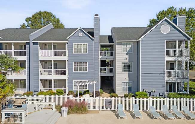 an image of an apartment building with chairs in front of it