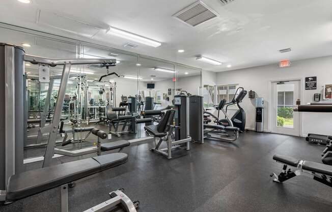 a gym with weights and cardio equipment on the floor and mirrors