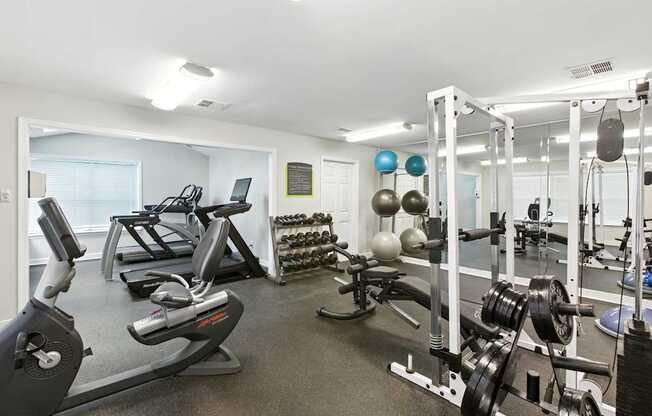 A well-equipped gym with a variety of exercise machines and weights.