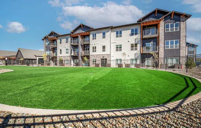 A large grassy area in front of a multi-story building.