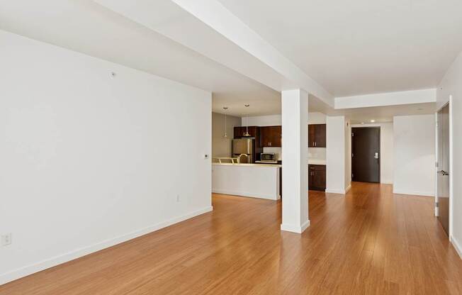 A spacious room with wooden floors and white walls.