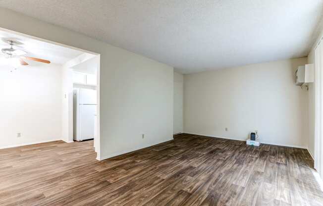 an empty living room with white walls and wood flooring