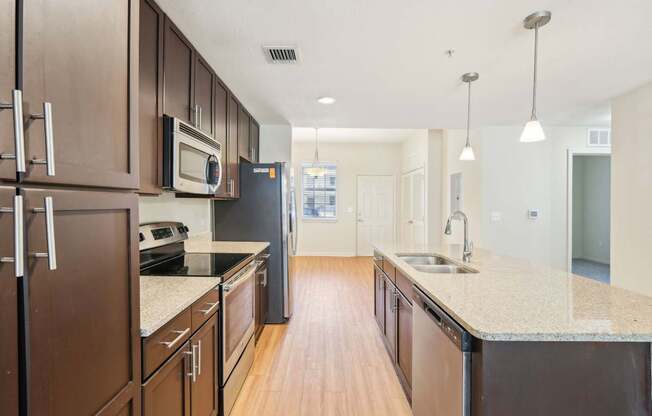 A kitchen with brown cabinets and a black refrigerator.