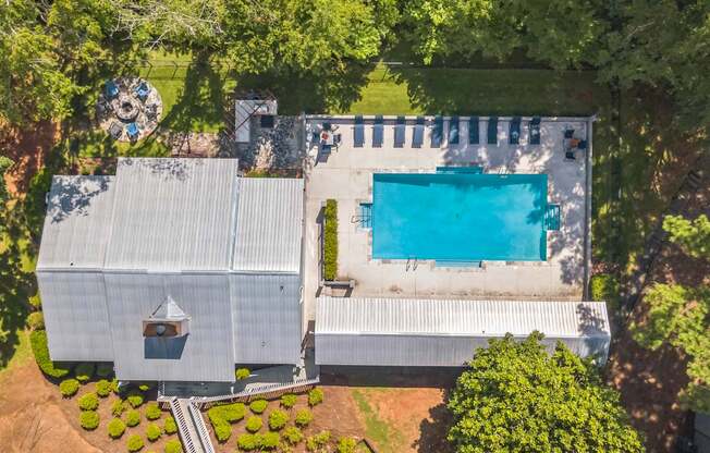 A large white building with a pool in front of it.