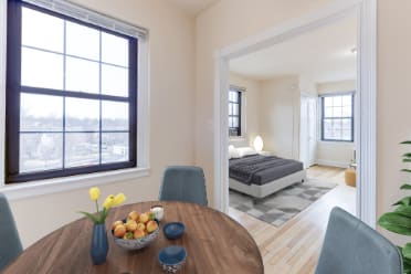 dining area with table, chairs, large windows and view of bedroom at the dahlia apartments in washington dc
