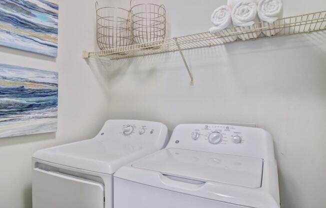 a white laundry room with a washer and dryer