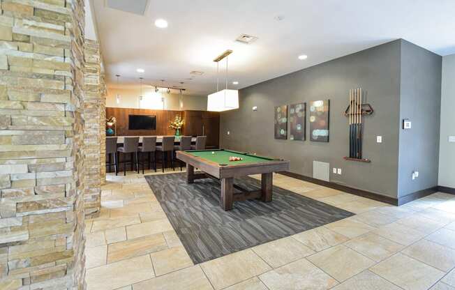 a billiards table in the clubhouse at the enclave at woodbridge apartments in sugar land