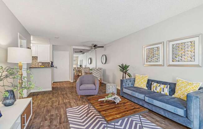 A living room with a blue couch and a wooden coffee table.