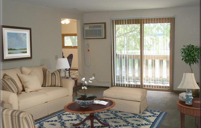 Bass Lake Crossing Apartment Living Room with Light Grey Carpet and Sliding Glass Door to Balcony