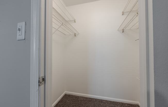 an empty closet in a room with white walls and a door