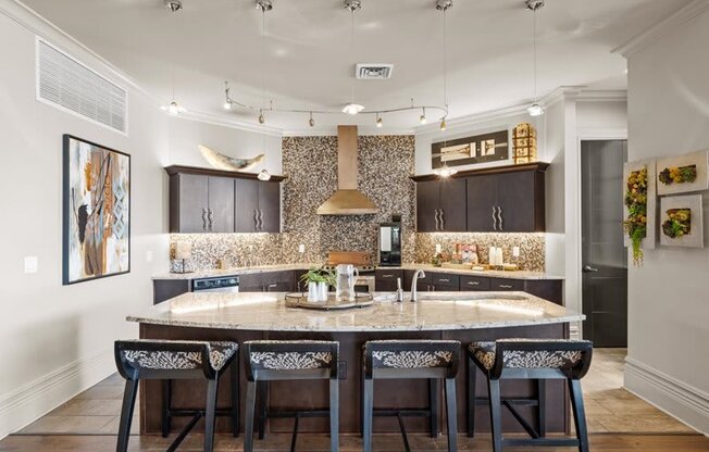 a kitchen with a large island with four chairs