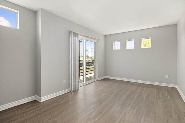 an empty living room with a sliding glass door to a balcony at NOHO GALLERY Apartments, North Hollywood , CA