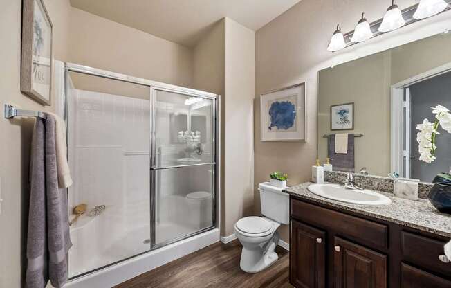 A bathroom with a toilet, sink, and shower.at The Equestrian by Picerne, Henderson Nevada