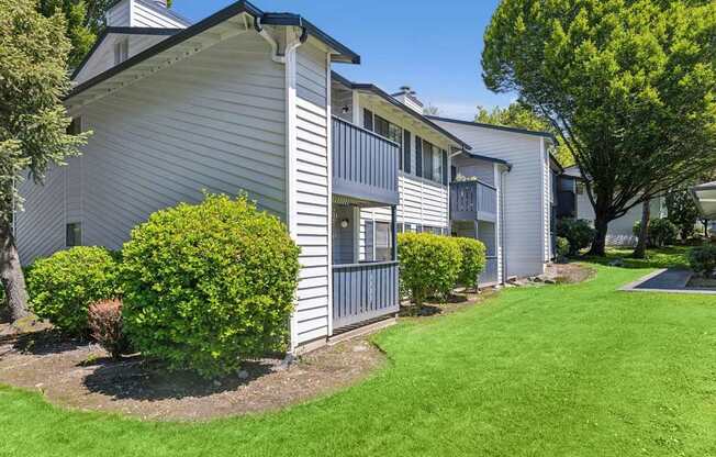 A white house with a green lawn in front.