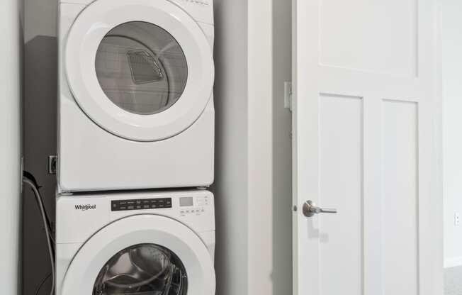 a white washer and dryer in a small laundry room