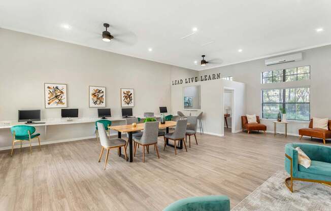 A room with a long table and chairs, a whiteboard, and a wall with a quote on it.