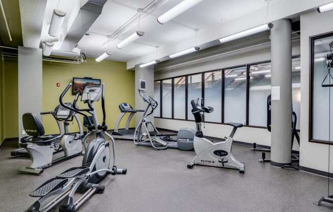 a gym with exercise bikes and windows in a building