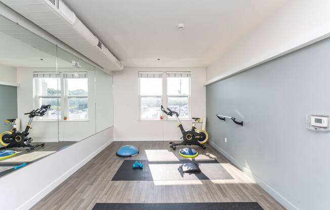 a workout room with yoga equipment and mirrors in a home gym