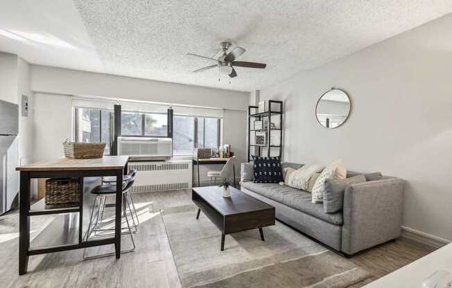 a living room with a couch and a table and a ceiling fan at Archer Tower in Denver, CO