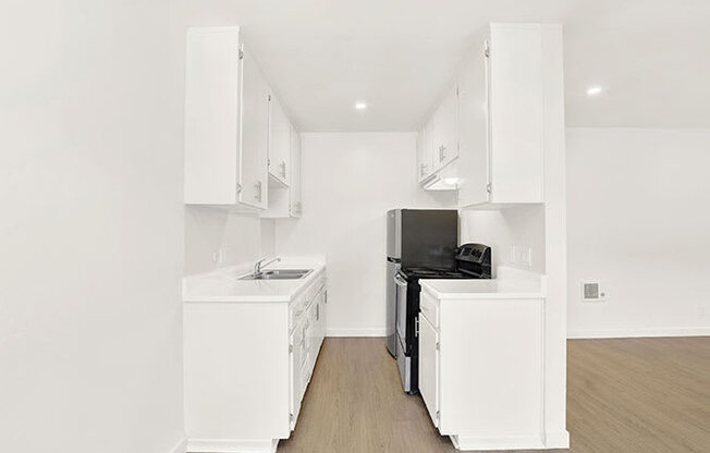 A kitchen with white appliances and cabinets.