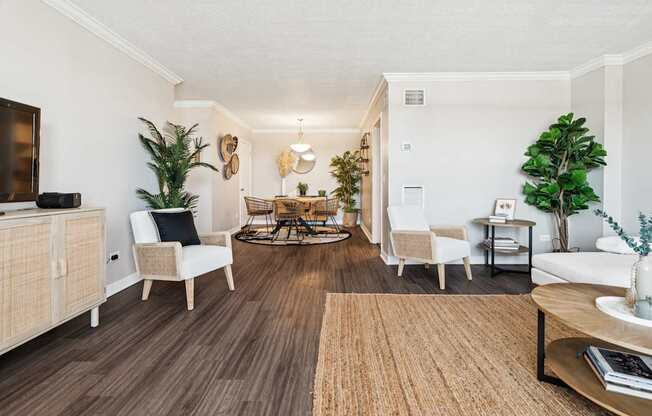 A living room with a brown rug and white furniture.