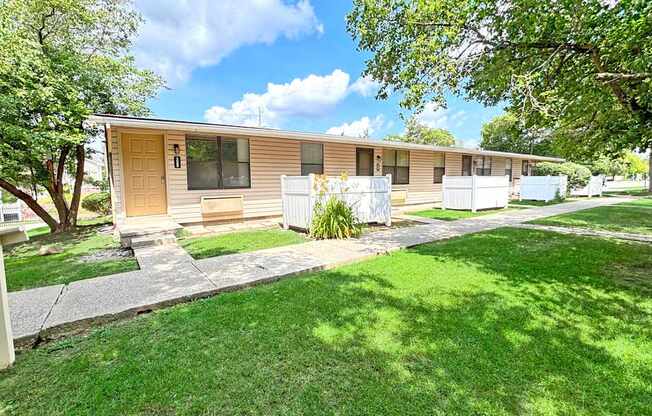 A row of houses with green lawns in front.