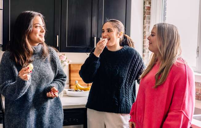 a group of women eating ice cream in a kitchen