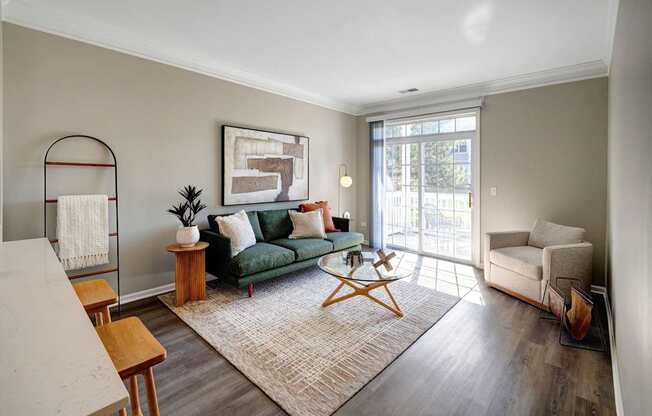 A living room with a green couch and a white chair.