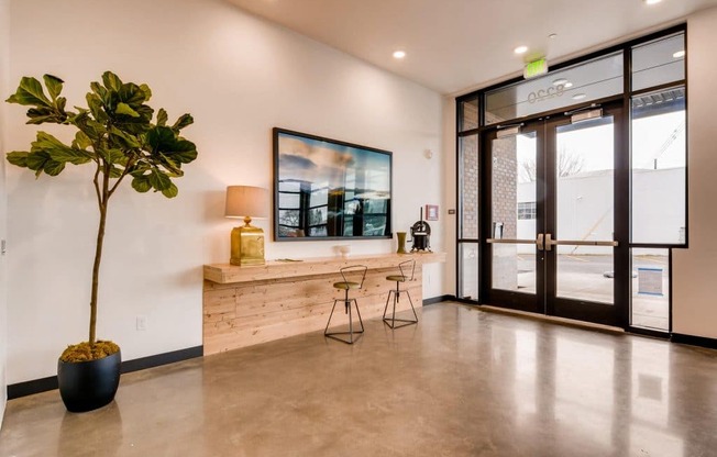 A room with a potted plant, a bench, and a painting on the wall.at Holm at Sellwood, Oregon