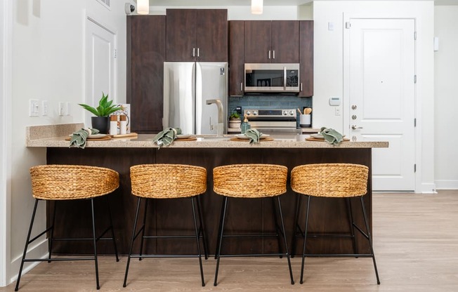 a kitchen with wooden cabinets and a counter with four stools