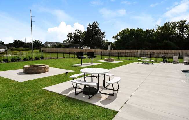 A picnic area with tables and a fire pit.