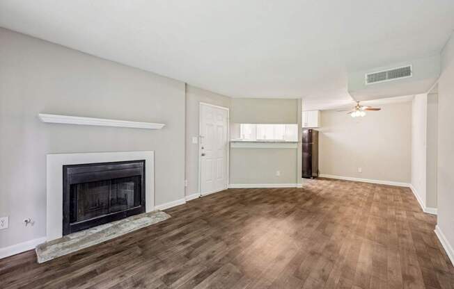 A living room with a fireplace that leads into the dining and kitchen area at Gwinnett Square Apartments in Duluth, GA