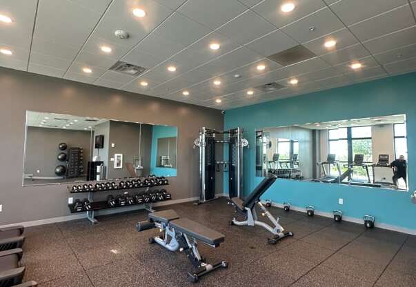 A gym with a variety of equipment including weights and machines.