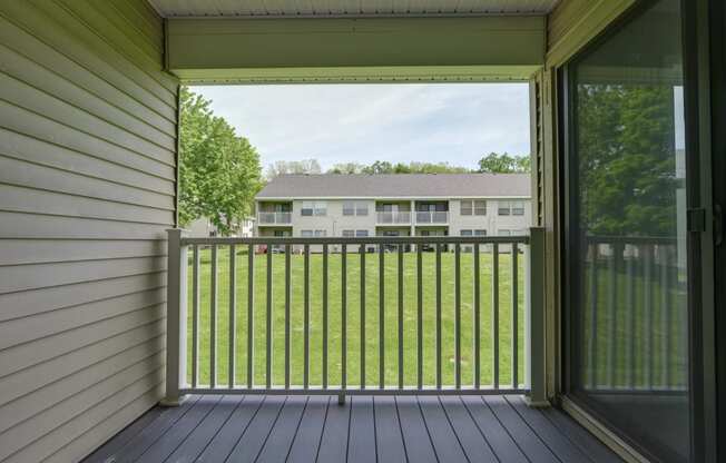 a balcony with a view of a yard and a house