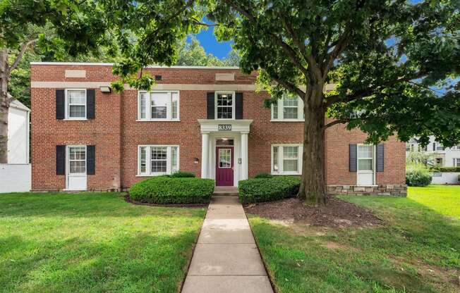 a red brick building with a sidewalk in front of it