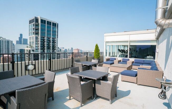 a rooftop patio with tables and chairs and a view of the city