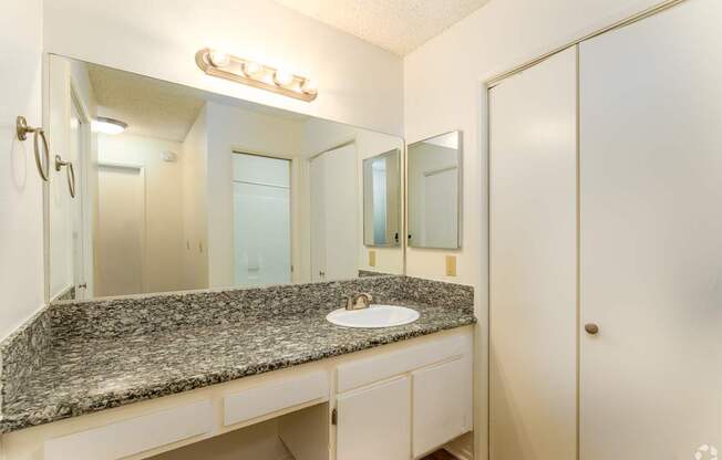 a bathroom with a granite counter top and a large mirror