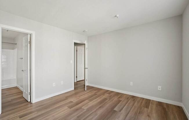 A room with wood flooring and white walls.