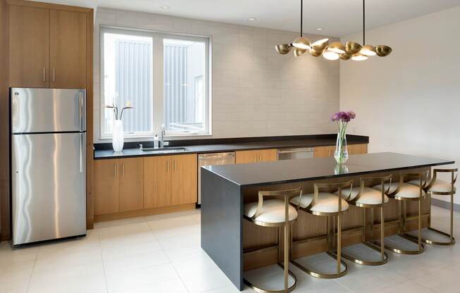 A modern kitchen with a large island and stools.