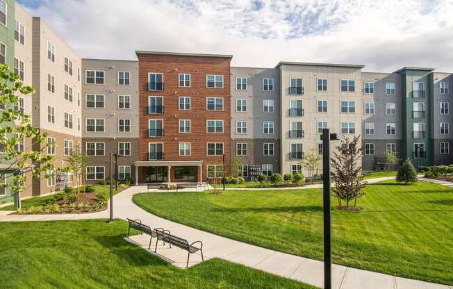 a park with a bench in front of an apartment building