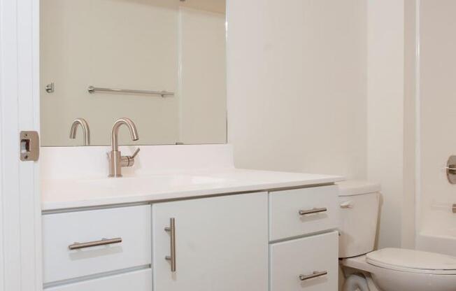 Spacious Bathroom with White Cabinetry and Silver Hardware at 700 Central Apartments, Minnesota, 55414