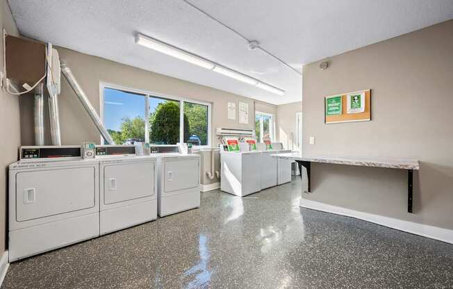 A clean, empty laundromat with washers and dryers.