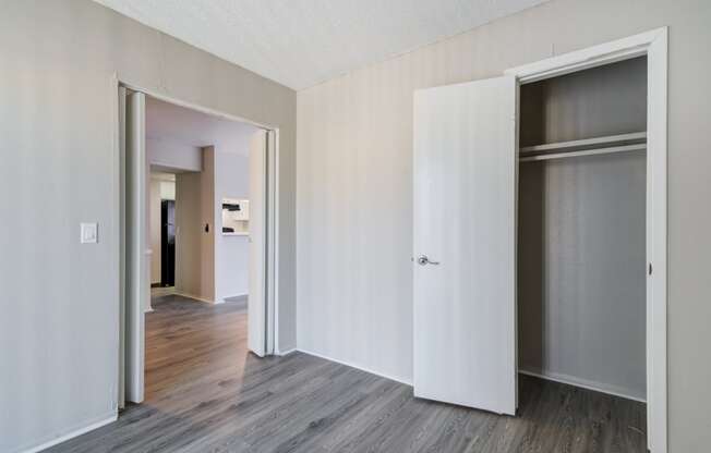 an empty room with white walls and sliding closet doors