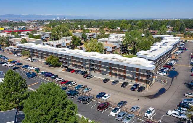 A parking lot with cars and a building in the background.