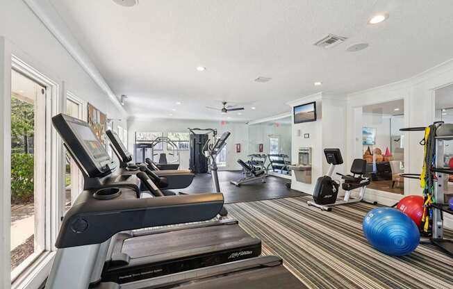 A gym with treadmills, exercise balls, and other equipment.