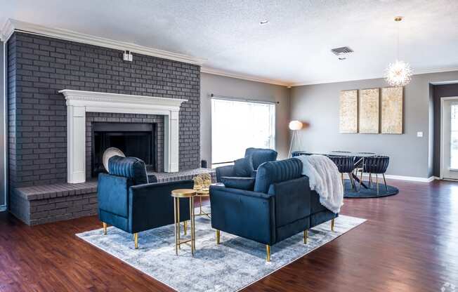a living room with blue furniture and a brick fireplace