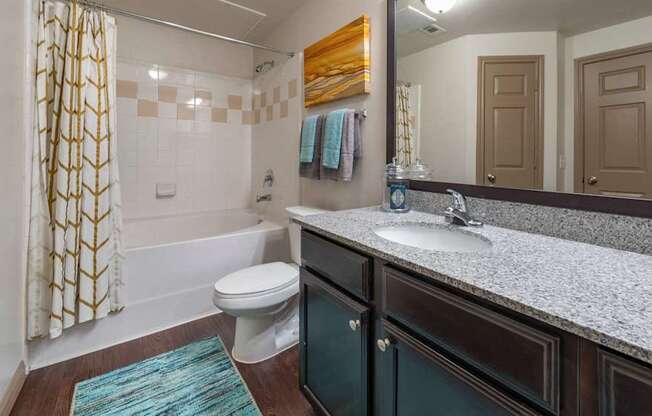 A bathroom with a toilet, sink, and shower.