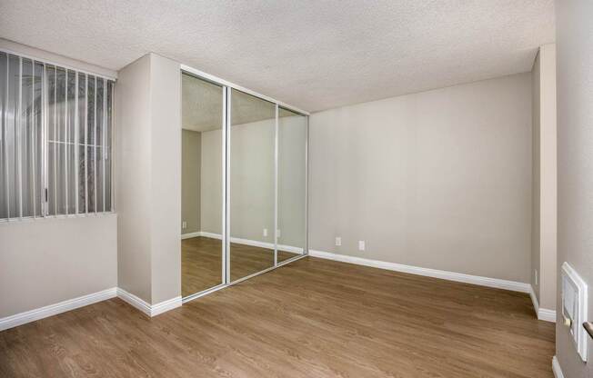A room with a sliding glass door and wooden flooring.