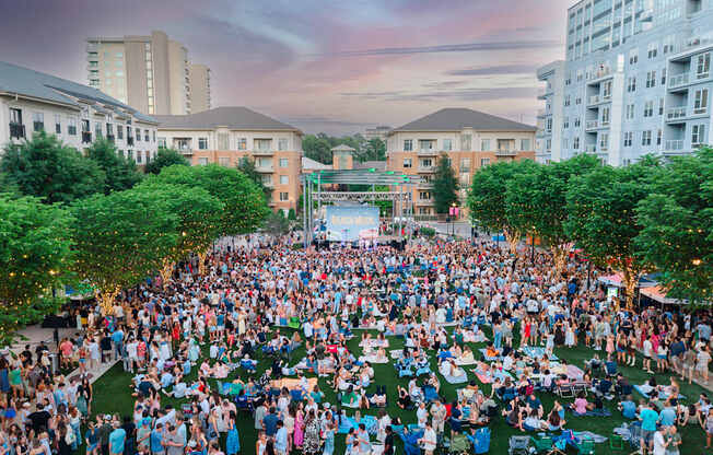 A large crowd of people gathered in a park-like setting.